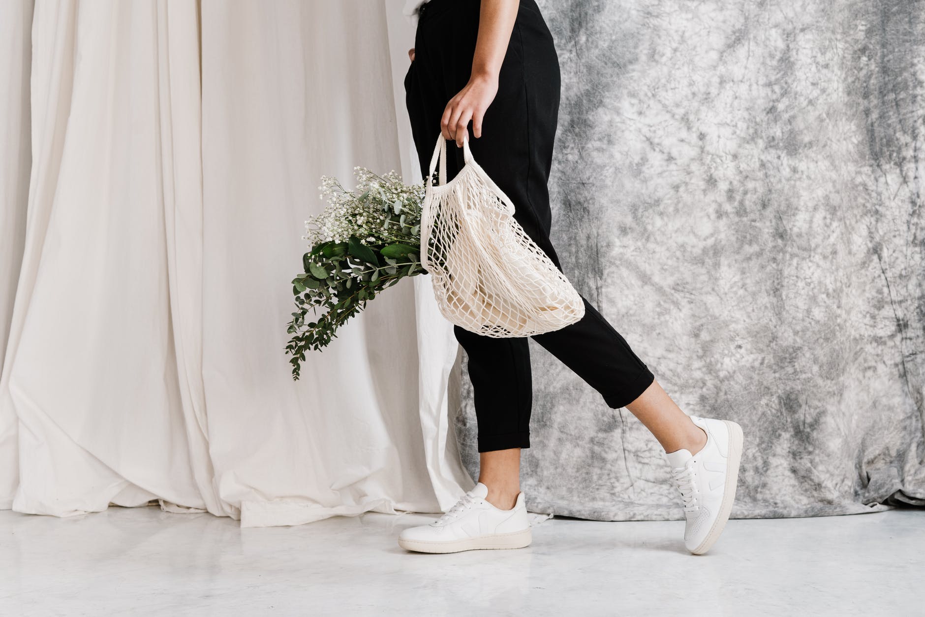 woman using reuseable bag to save plastic whilst shopping at zero waste shop to help your sustainable new year resolutions